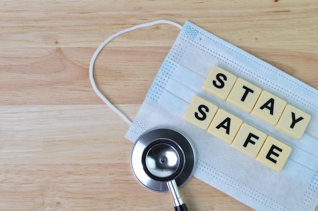 Top view of face mask stethoscope and square letters with text STAY SAFE