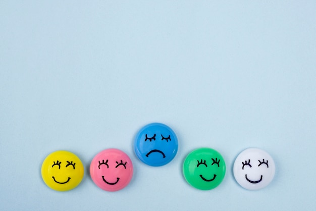 Top view of faces with sad and happy emotions for blue monday with copy space