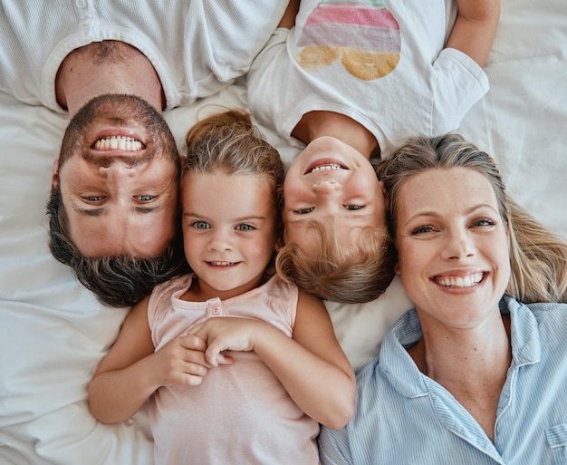 Top view family and portrait in bedroom home bonding or having fun Love care and happy kids or girls mother and father enjoying good time together smiling or laughing while relaxing in house