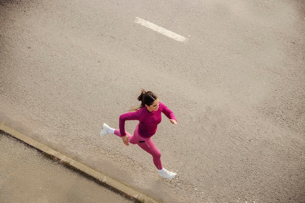 Top view of a fast female runner running on driveway