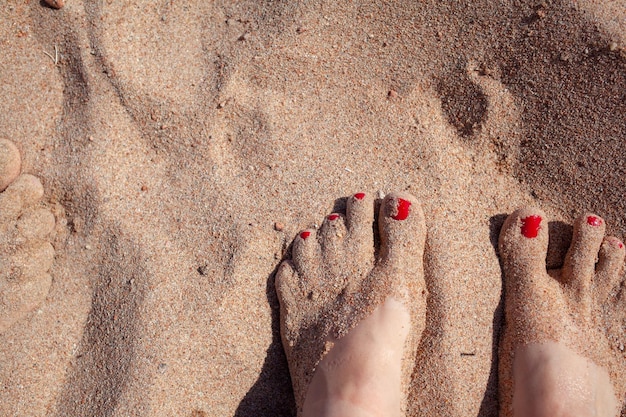 Top view of feet in the sand on a sledge A woman or a man is standing