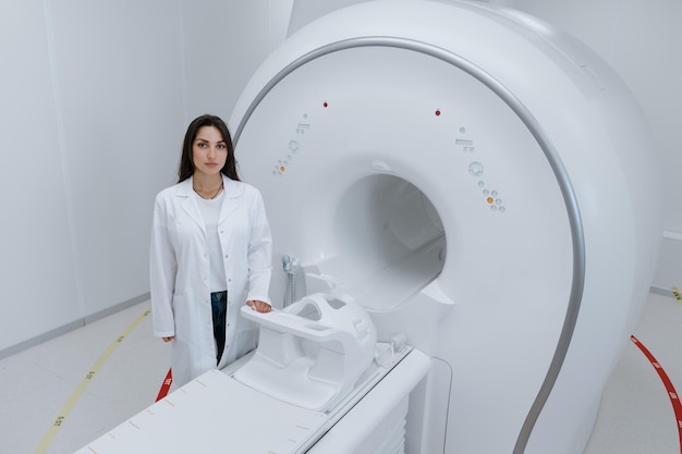 Top view of a female doctor in a white coat standing next to a magnetic resonance imaging machine Modern equipment for diagnostics in the clinic