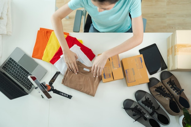 Top view of female entrepreneurs Packing products into boxes for ecommerce orders for delivery