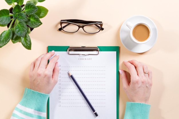 Top view female hand writes list makes notes