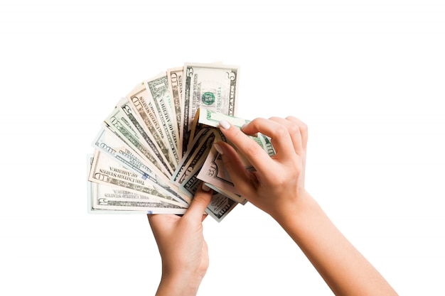 Top view of female hands counting a fan of dollar bills