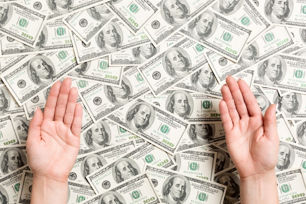 Вид сверху женских рук на фоне доллара