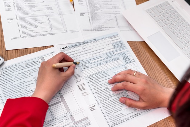 Top view on female hands filling 1040 tax form