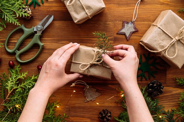 Top view on female hands tying holiday craft gift box