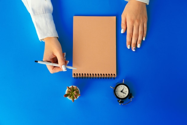 Top view of female hands writing in notebook