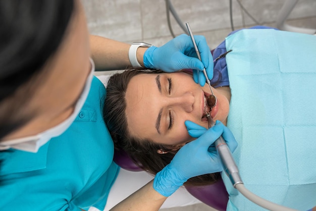 Top view of female patient teeth whose teeth looks at dentist woman