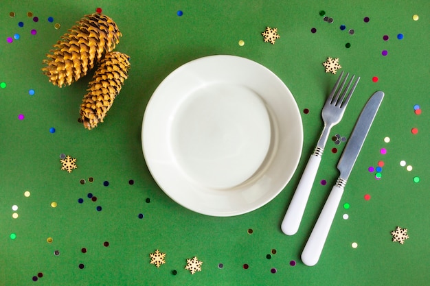 Top view of festive Christmas table setting on green with confetti