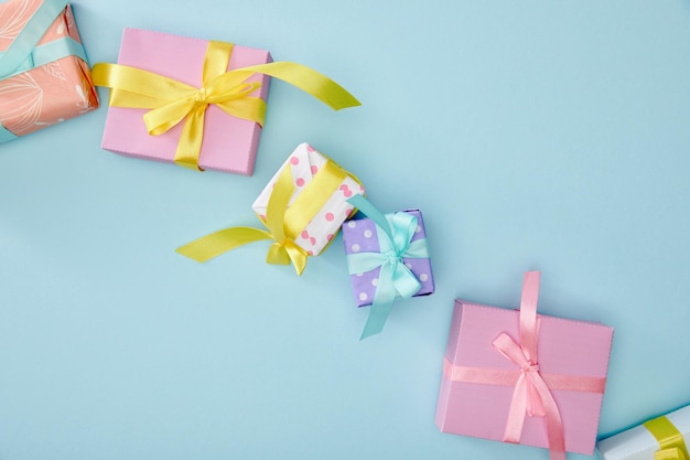 Top view of festive colorful gift boxes on blue background