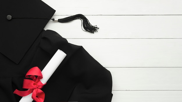 Top view festive graduation composition on wooden background