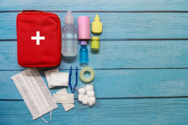 Top view first aid bag kid with medical supplies on wood