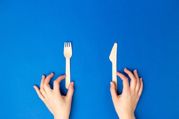 Top view and flat lay of bamboo wooden cutlery isolated on blue background