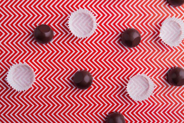 Вид сверху плоские шоколадные конфеты и обертывания