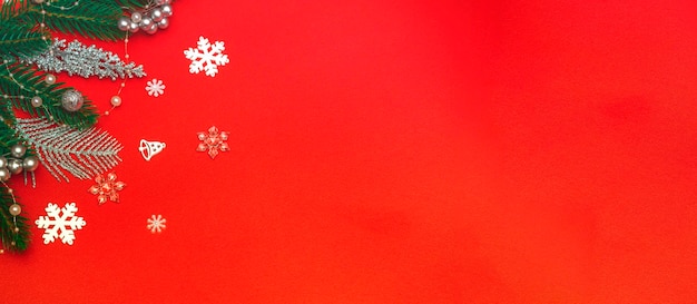 Top view of a flat lay of Christmas decorations on a red background. Concept for postcard, announcement, banner. With copy space