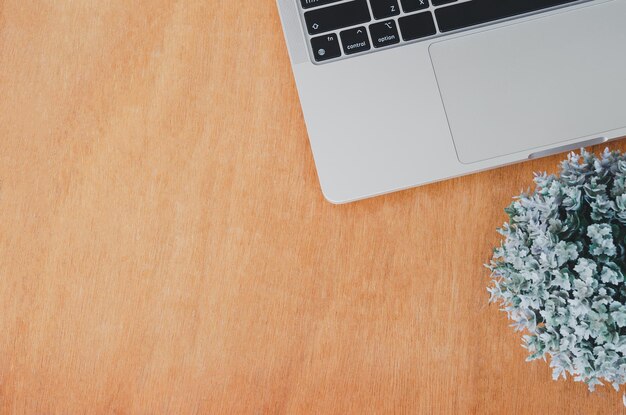 Photo top view flat lay computer laptop and flower on wood table