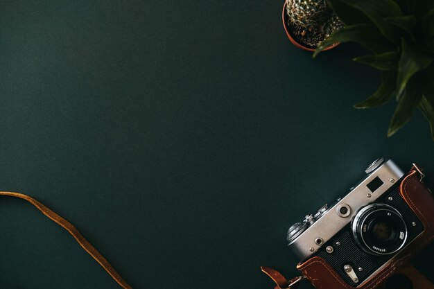 Top view of the flat lay of a film camera lying on an empty dark table. Concept workspace of an artist or journalist. Advertising space