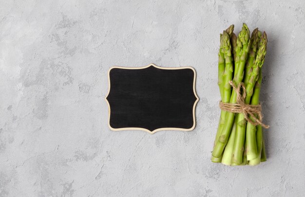 Top view flat lay of fresh green asparagus on gray concrete table