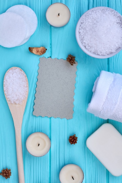 Top view flat lay items for spa treatment on blue wood. Vertical shot copy space.