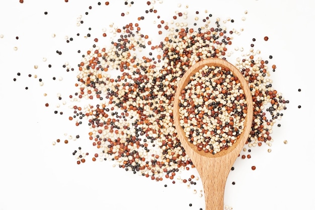 top view or flat lay quinoa seeds in wooden spoon isolated on white background. close up quinoa seed