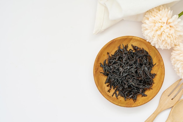 top view or flat lay seaweed sargassum fusiforme or Hijiki seaweed in wood plate on white background