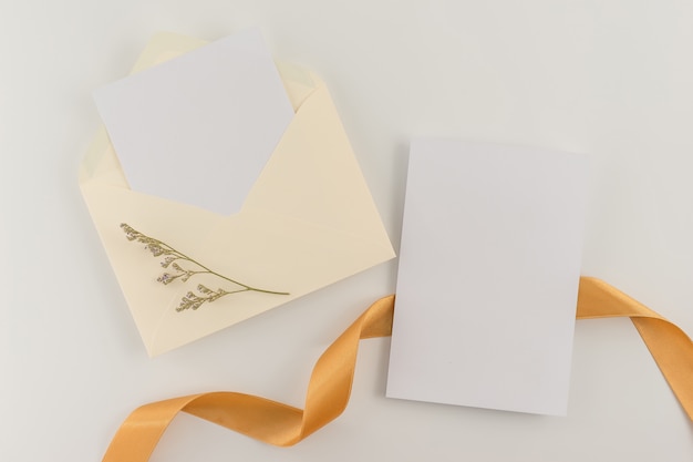 Photo top view, flat lay, wedding invitation card, envelopes, cards papers on white background.