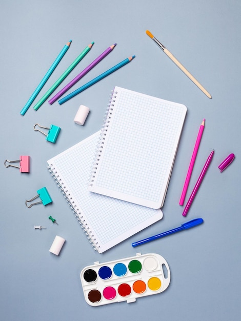 Top view of a flat work desk lies a notebook with blank sheets and stationery Template for women's blogs in social networks