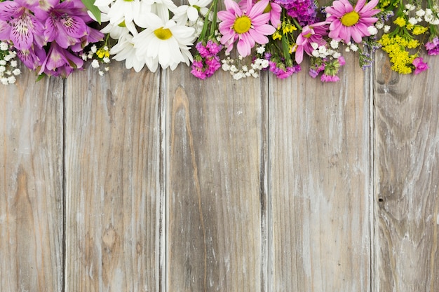 Top view floral frame with wooden background