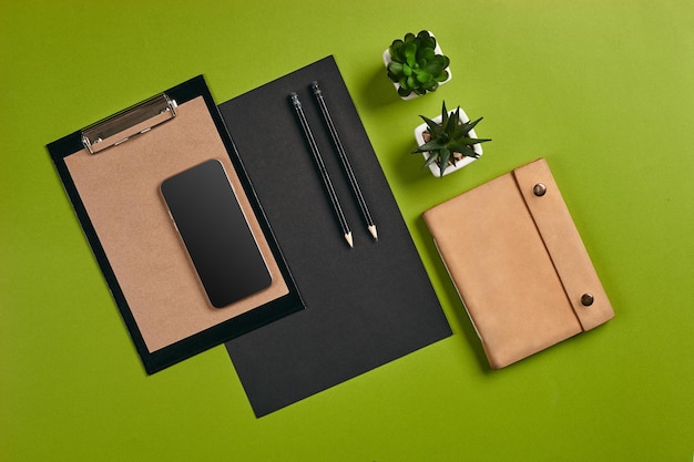 Top view in focus with different office equipment supplies stationery green background with copy spa