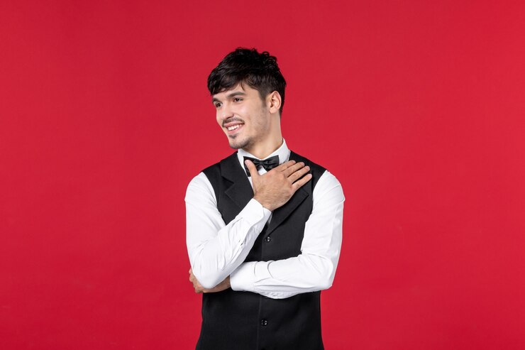 Photo 蝶ネクタイと制服を着た集中男性ウェイターの上面図。