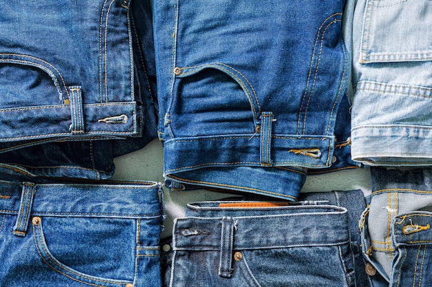 Top view of folded jeans,Blue jeans on a stack of jeans . Top view of various denim fabrics on white