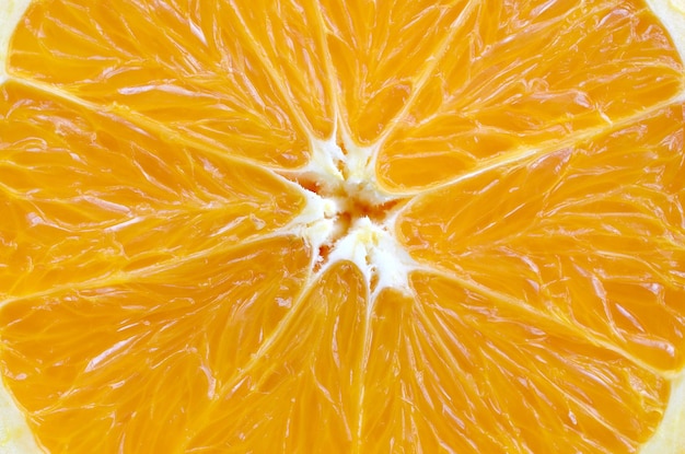 Photo top view of a fragment of the orange fruit slice close up macro background texture