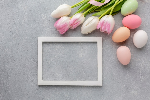 Foto vista dall'alto del telaio con colorate uova di pasqua e bellissimi tulipani