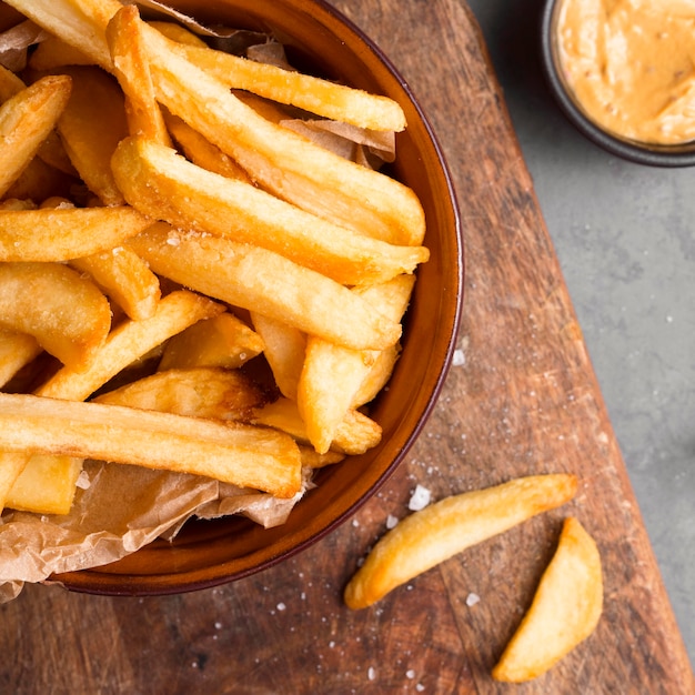 Top view of french fries in bowl with salt