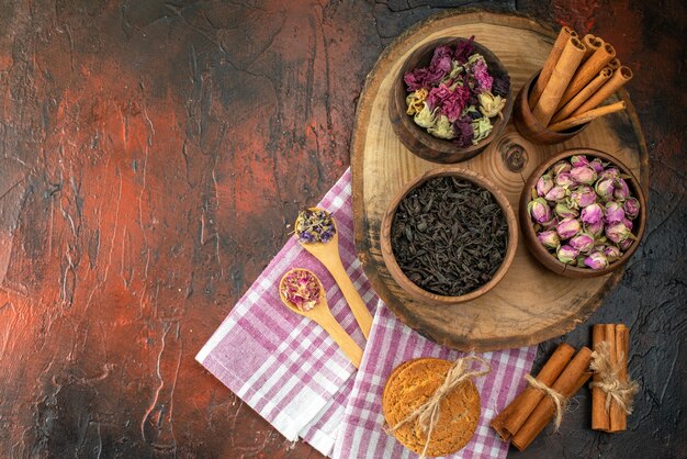 Vista dall'alto tè nero fresco con biscotti e fiori su sfondo scuro sapore di tè colore foto fiore bevanda al caffè