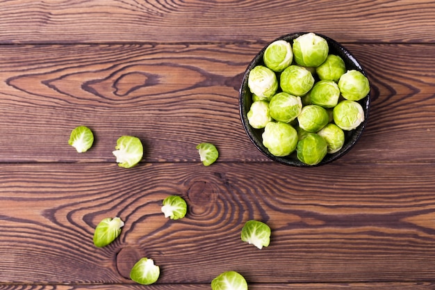 Photo top view of fresh brussels sprouts on a wooden table. place for text. flat lay.