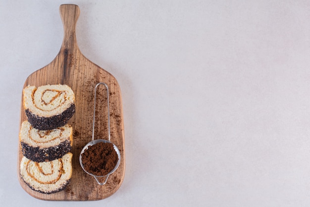 Top view of fresh cake rolls with powder on wooden board 