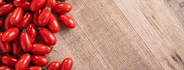 Top view of fresh cherry tomatoes over wooden table background