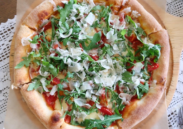 Top view of fresh cooked pizza with arugula and cheese