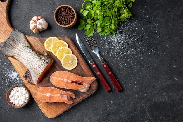 top view fresh fish with lemon and greens on a dark background meal salad seafood water fish meat sea ocean food