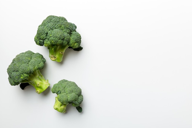上面図色付きの背景に新鮮な緑のブロッコリー野菜ブロッコリーキャベツの頭健康またはベジタリアン料理のコンセプトフラットレイコピースペース