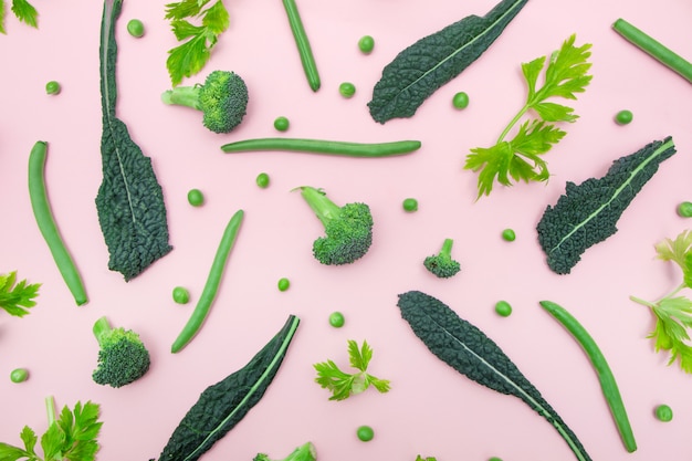 Top view of fresh green vegetables on the pink color surface