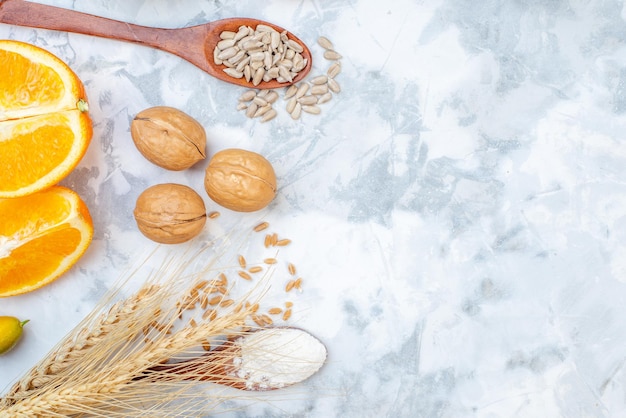 Top view of fresh oranges eggs raw oatmeal walnuts on the right side on ice background