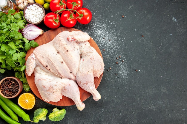 top view fresh raw chicken with greens and red tomatoes