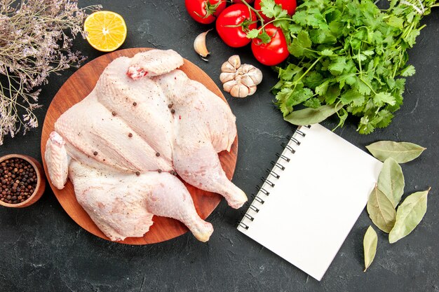 top view fresh raw chicken with greens and red tomatoes