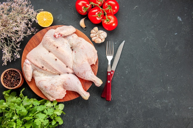 top view fresh raw chicken with greens and red tomatoes