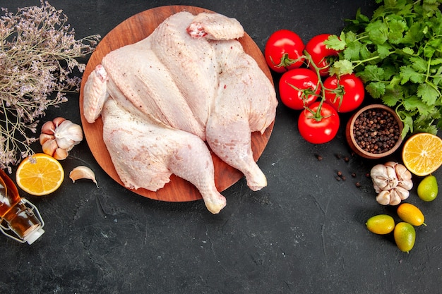 Vista dall'alto pollo crudo fresco con pomodori verdi e condimenti