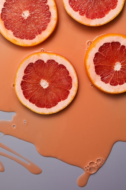 Вид сверху на свежий ломтик грейпфрутового сока и гелевой сыворотки органической косметики